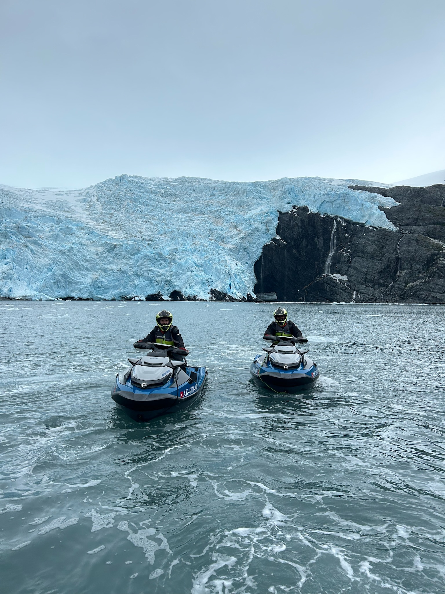 Ariel and Vai on jet skis in front of a glacier