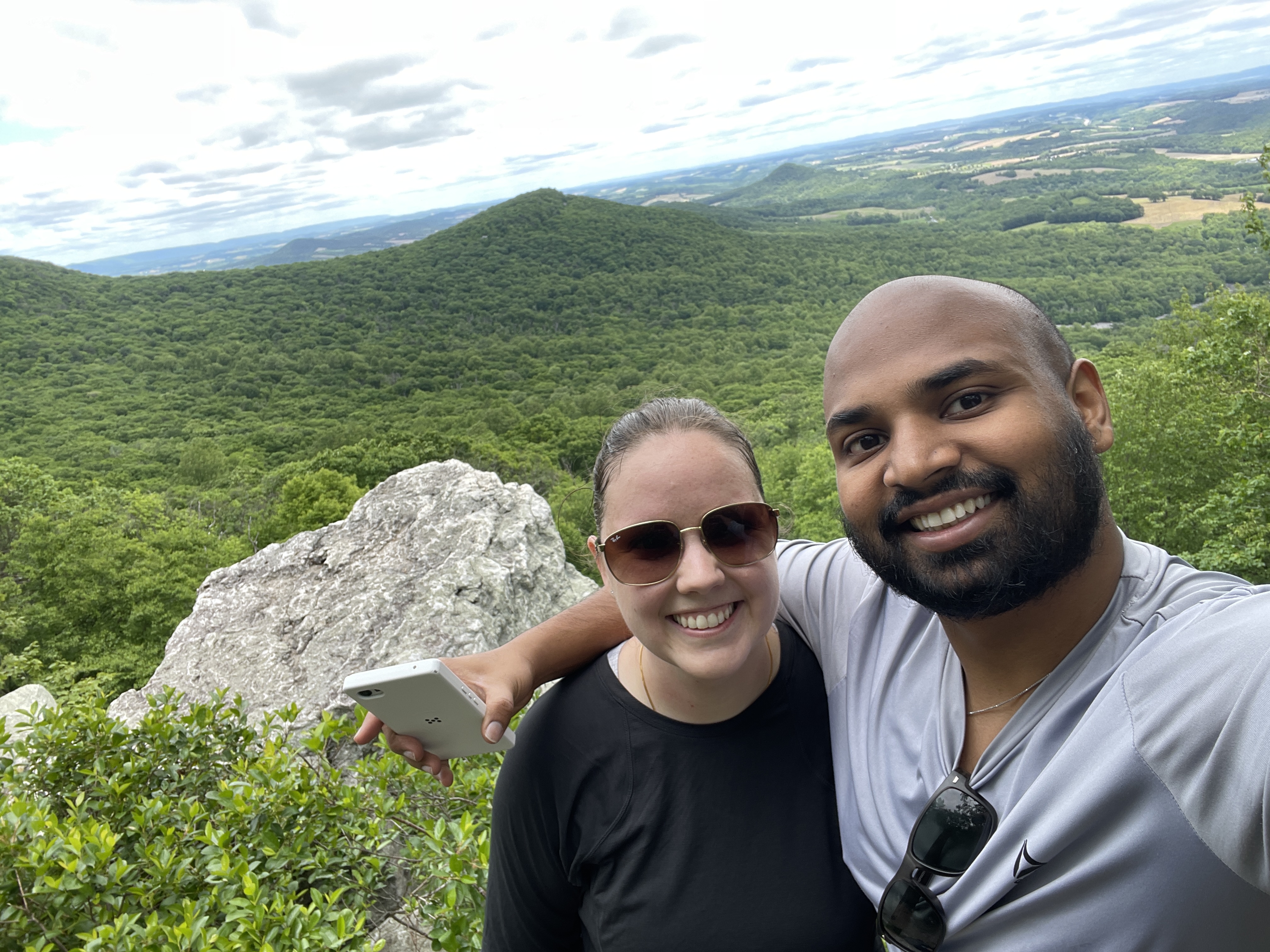 Ariel and Vai smiling together at a mountain overlook