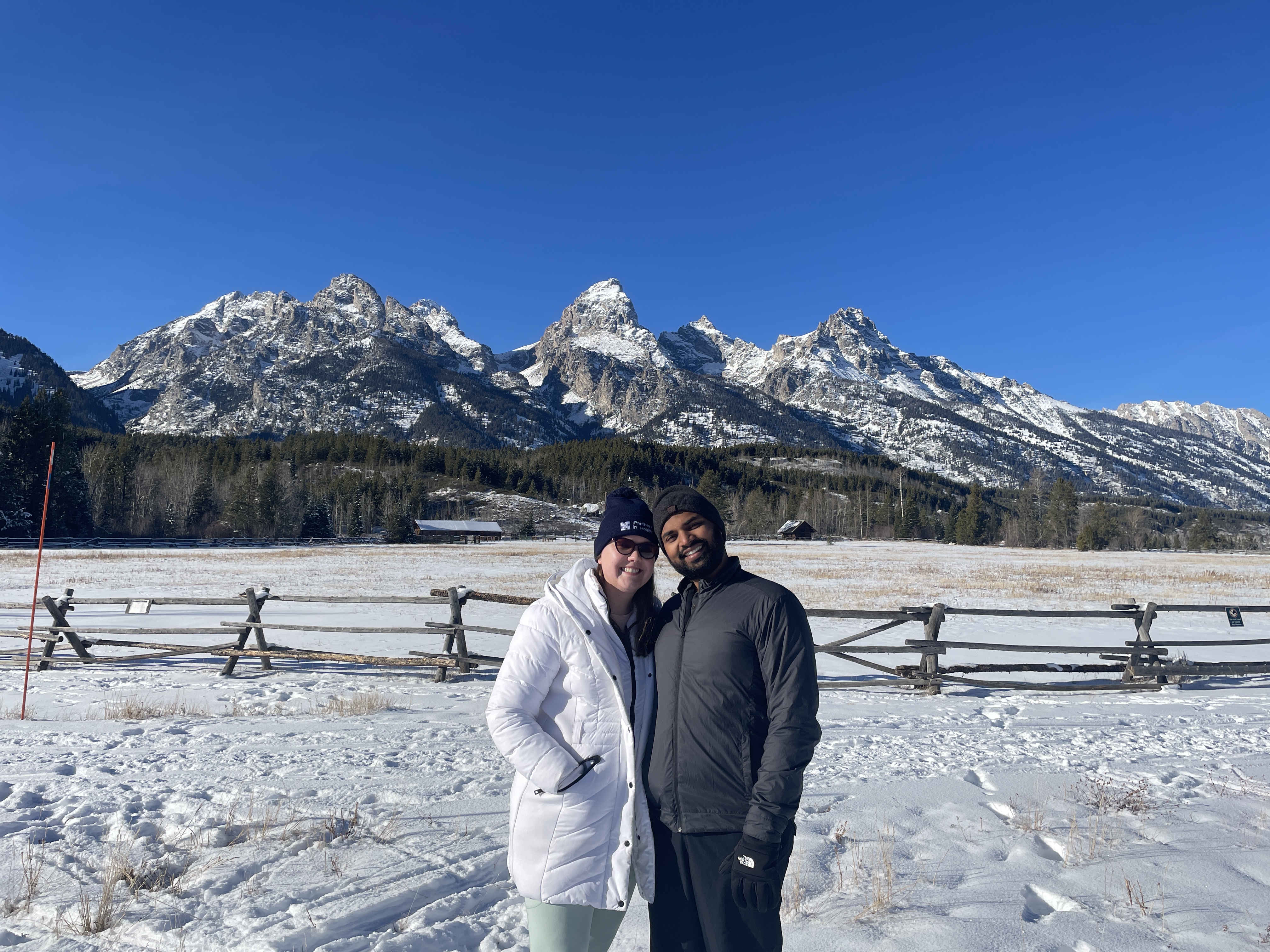 Ariel and Vai standing together in the snow with mountains behind them